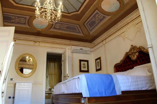 a bedroom with a large bed with a chandelier at Les Suite Royales in Sassari