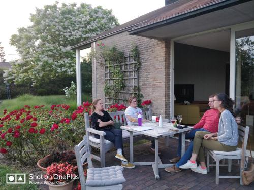 a group of people sitting around a table on a patio at La Petite Bruyere De Renaix in Ronse