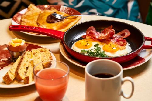 a table with a breakfast of eggs and bacon and toast at Mama Shelter London - Shoreditch in London