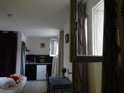 een slaapkamer met een bed, een bureau en een raam bij Studio au Centre d'Art ARKAD in Auvillar