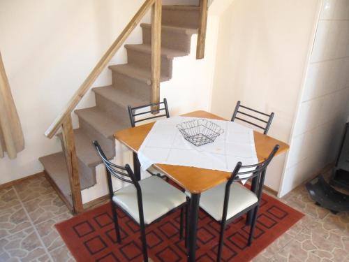 a table and chairs in a room with stairs at Cabañas Bosque Sur in Puerto Varas