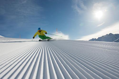 a person is skiing down a snow covered slope at Hotel Sonnenheim in Sankt Anton am Arlberg