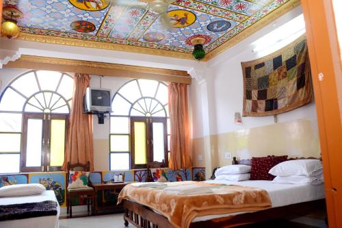 a bedroom with a large bed and a ceiling with mosaicism at Kasera Heritage View in Būndi
