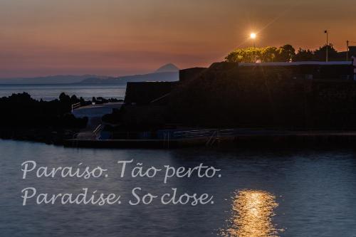 Ein Sonnenuntergang über dem Wasser mit den Worten Panama-Reise Perico Perico in der Unterkunft Quinta Do Martelo in Angra do Heroísmo