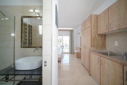 a bathroom with a sink and a bath tub at La Santa in Chrysi Ammoudia