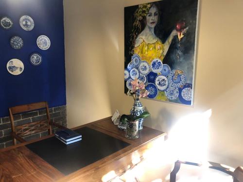 a room with a table with a painting on the wall at Bella Blue Guesthouse in Bloemfontein