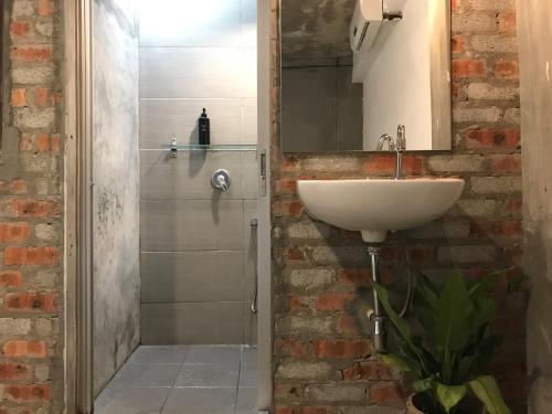 a bathroom with a white sink and a shower at The Frame Guesthouse in George Town