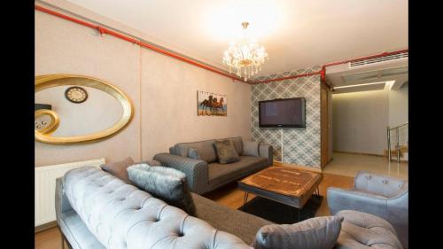 a living room with a couch and a tv at CTS Elysium Residence Taksim in Istanbul