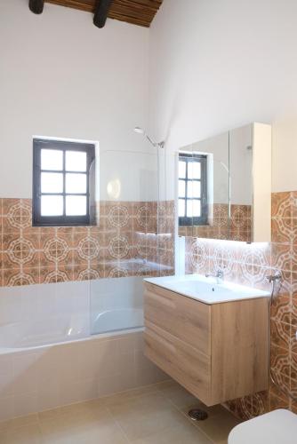 a bathroom with a tub and a sink and a shower at Algarve booking Casa Alfarrobeira Benagil Caves private parking airco heated private pool - AL in Carvoeiro