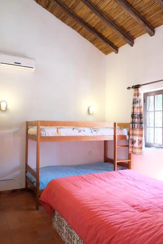 a bedroom with two bunk beds and a red bed at Algarve booking Casa Alfarrobeira Benagil Caves private parking airco heated private pool - AL in Carvoeiro