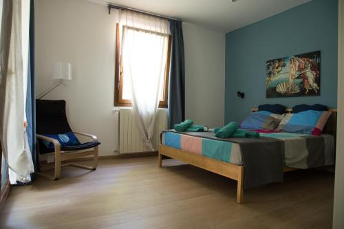 1 dormitorio con 1 cama, 1 silla y 1 ventana en Appartamento con giardino Le Querce, en Sistiana