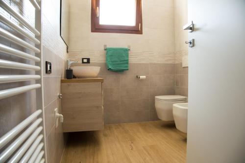 a bathroom with a toilet and a sink at Appartamento con giardino Le Querce in Sistiana