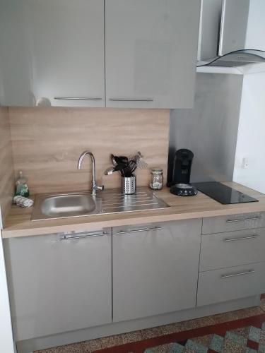 une cuisine avec des armoires blanches et un évier dans l'établissement imperatrice 2, à Berck-sur-Mer