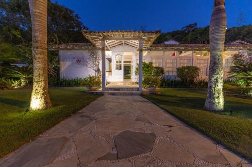 a home with a stone walkway leading to the front door at Pousada Bucaneiro in Búzios