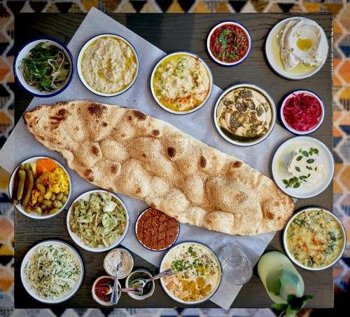 a table full of different types of food with a pita at Arlo NoMad in New York