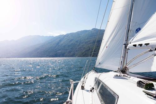 a sailboat on the water with mountains in the background at Hotel Eden Roc - The Leading Hotels of the World in Ascona