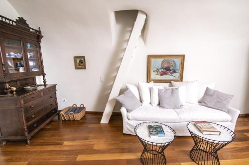 a living room with a white couch and two tables at Aloia Villas in Oia
