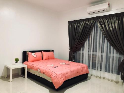a bedroom with a bed with pink sheets and a window at Family homestay in Kuala Selangor