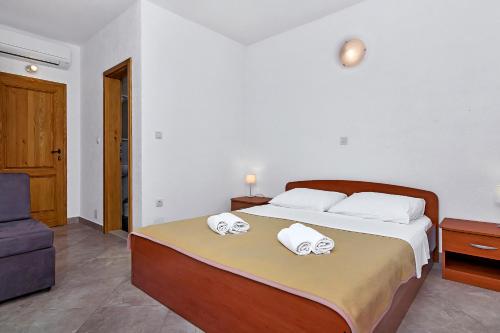 a bedroom with a bed with two towels on it at Apartmani Nikola in Zastražišće