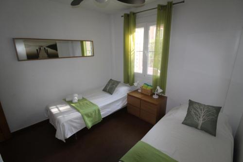 ベナアビスにあるBenahavis Penthouse Apartmentのベッドルーム1室(ベッド2台、鏡、窓付)