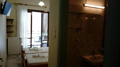 a bathroom with two beds and a sink and a shower at Kadmos in Loutra Edipsou