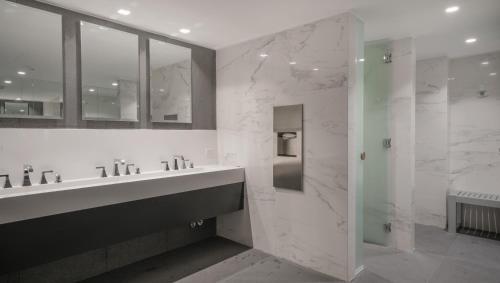 La salle de bains est pourvue de 2 lavabos et d'une douche en verre. dans l'établissement Top Rentals Belgrano, à Buenos Aires