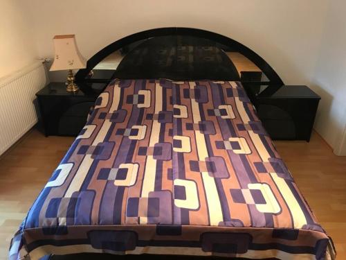 a bed with a colorful quilt on top of it at Tri šešira Ljubovija in Ljubovija