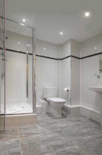 a bathroom with a shower and a toilet and a sink at The Castle Collection - 25 Castle Street in Liverpool