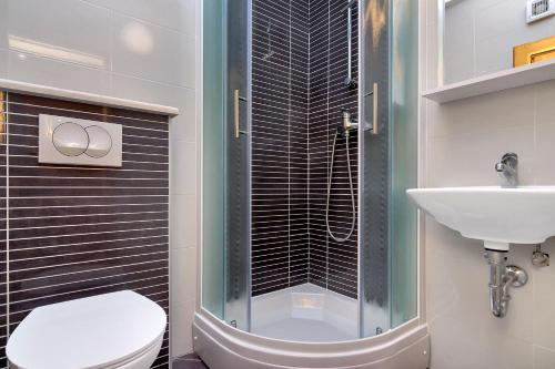 a bathroom with a shower and a toilet and a sink at Apartmani Nikola in Zastražišće