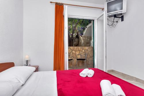 a bedroom with a bed with a red blanket at Apartmani Nikola in Zastražišće