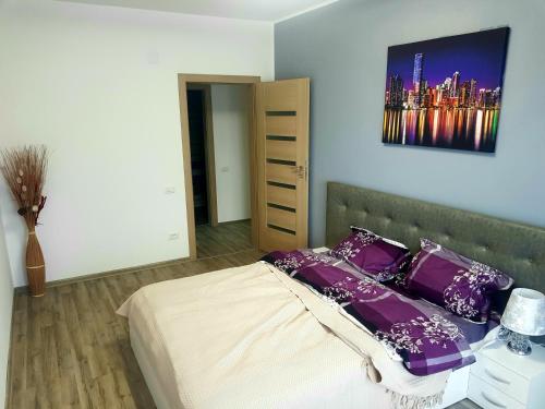 a bedroom with a bed with purple pillows at Skyline Rooftop Condos in Oradea