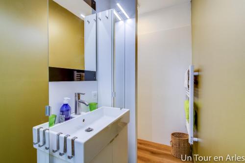 a bathroom with a white sink and a mirror at Un tour en Arles in Arles