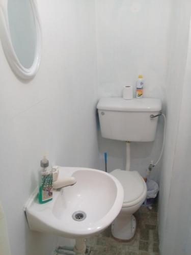 a white bathroom with a toilet and a sink at SLEEP-Inn in Scarborough