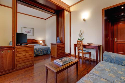 a hotel room with a bedroom with a bed and a desk at Hotel Continental in Santa Margherita Ligure