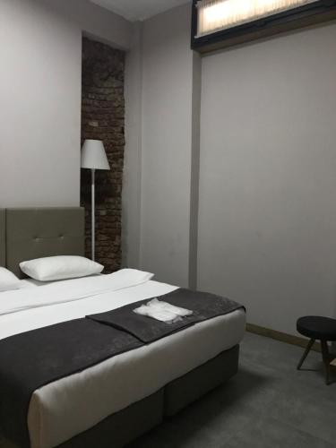 a bedroom with a large bed and a lamp at Jurnal Hotel in Istanbul