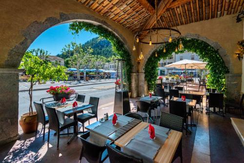 an outdoor restaurant with tables and chairs and a street at Hotel du Levant in Castellane