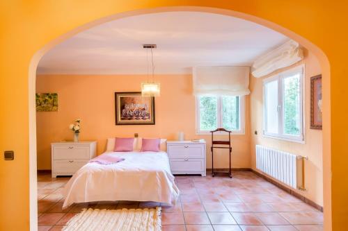 una camera da letto con pareti arancioni e un letto con cuscini rosa di Jaza Paraiso a Cercedilla