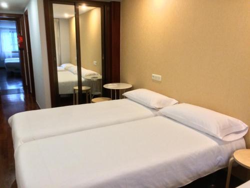 a hotel room with a bed and a mirror at Saudade Hostal Cafetería in A Coruña