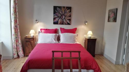 Schlafzimmer mit einem großen roten Bett und Holzboden in der Unterkunft Le Clos des Roseaux in Chorey-lès-Beaune