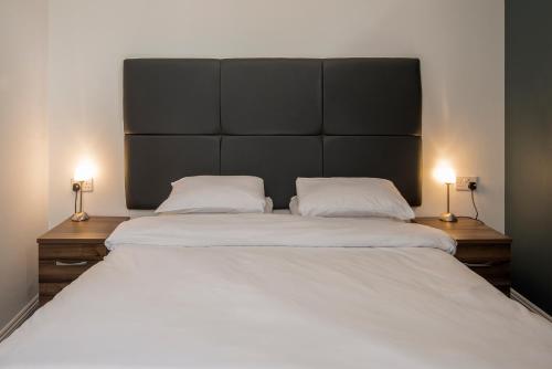 a large bed with two white pillows and two lamps at The Castle Collection 14 Cook Street in Liverpool