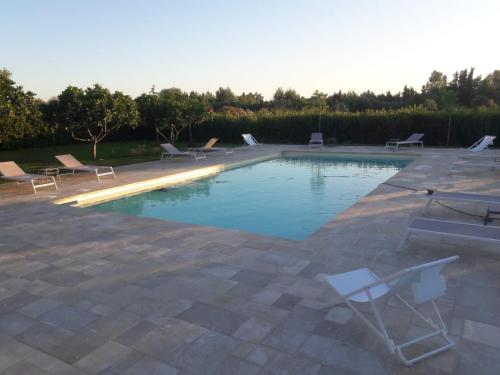una piscina con tumbonas en un patio en Masseria Mattiani, en Campi Salentina