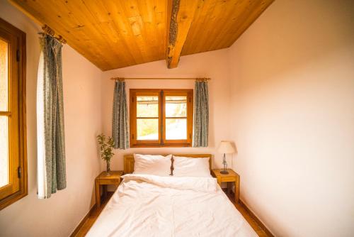 - une chambre avec un lit, une fenêtre et 2 tables dans l'établissement Maison Hameau De La Mourre (La Garde-Freinet), à La Garde-Freinet