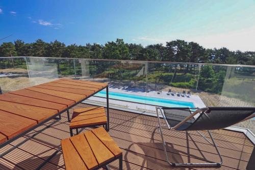 a balcony with a table and chairs and a swimming pool at Inselloft Rügen - Meerblick, Pool & eigener Strandzugang in Binz