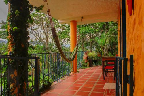 a porch with a hammock on a house at Casa Encuentro Ecolodge, Outdoor Gym and Yoga in Guatapé