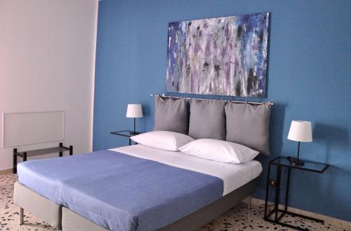 a blue bedroom with a bed with a painting above it at Casa Rosetta in Palermo