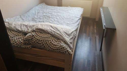 a bed in a bedroom with a wooden floor at StudioSpanie beach room small in Sopot