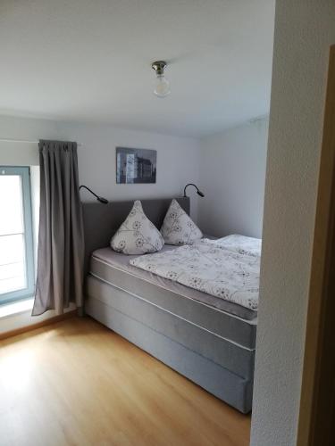 a bed with two pillows in a room with a window at Pension am Pferdemarkt in Güstrow