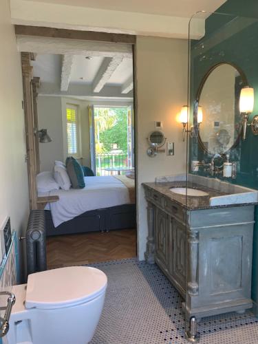a bathroom with a sink and a mirror and a bed at Bradleigh Lodge in St Austell