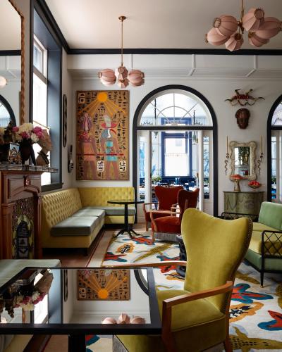 a living room with yellow chairs and a table at Maison Metier, in the Unbound Collection by Hyatt in New Orleans