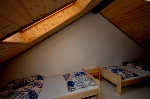 Cette chambre mansardée comprend 2 lits et une mezzanine. dans l'établissement Apartamenty pod Skałą, à Polańczyk